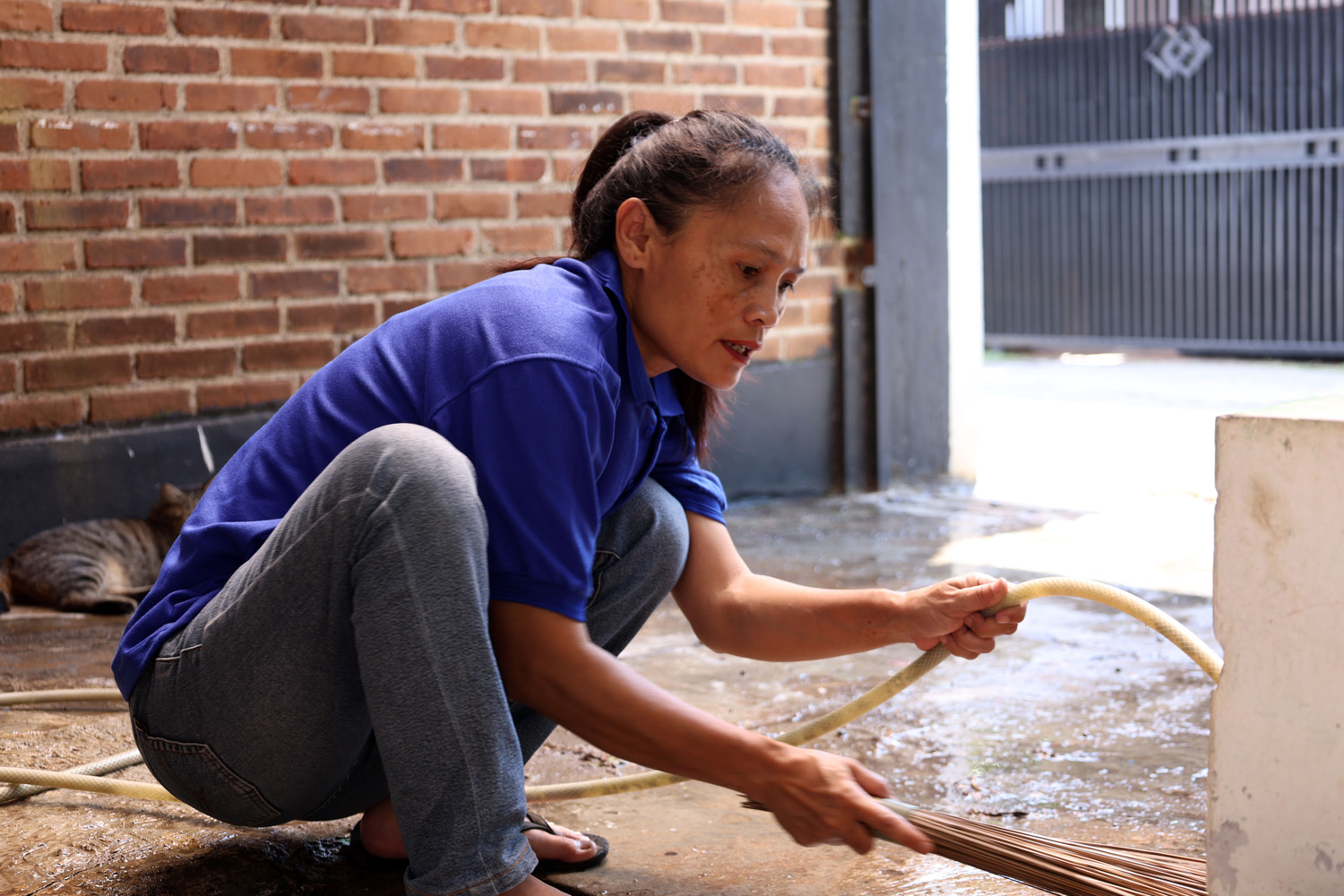 Restoration worker cleaning water from a damaged residential floor